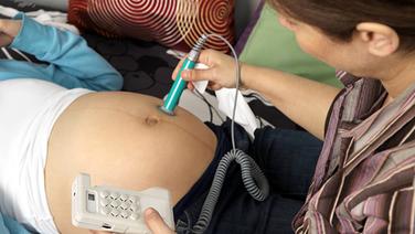 Hebamme kontrolliert Herztöne des Fötus.